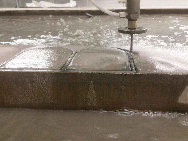 Waterjet cutter cutting through a thick piece of metal