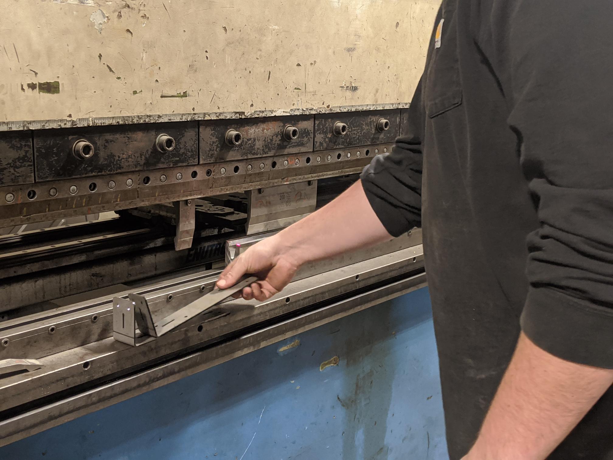 A person handles parts made in the press machine