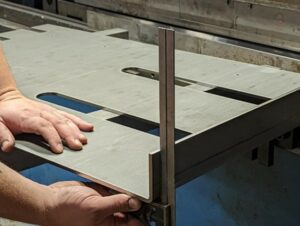 person checking the accuracy of a metal-formed piece